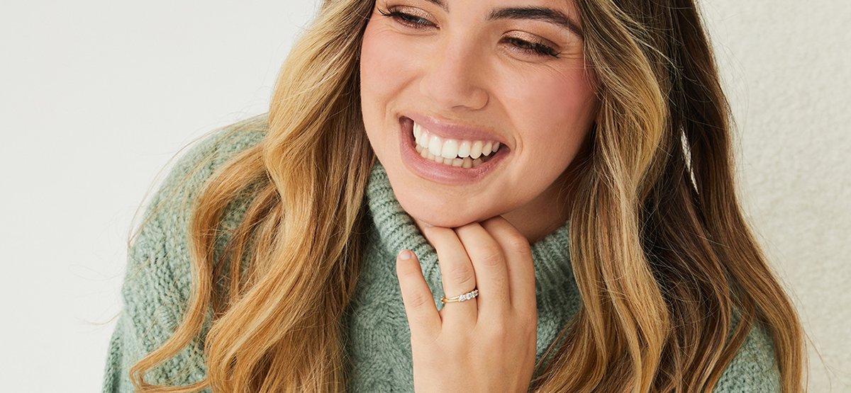 girl smiling wearing a turtle neck sage jumper