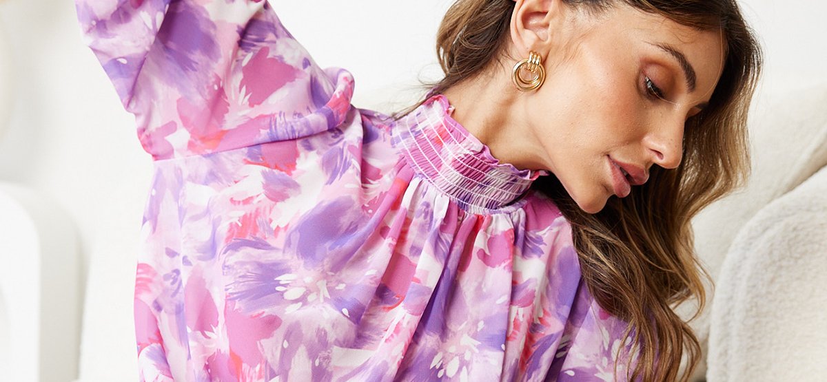 side view of a girl wearing a purple printed high neckline dress