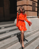 Full length view of model wearing the Daenerys Orange Print Mini Dress styled with strappy heels