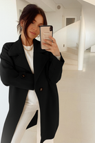 Women wearing the Fireplace Coat in Black, a classic knit trench coat with open-front silhouette and cuff detail