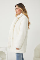 Model wearing the Bernie Ivory Jacket styled with a slip dress and heels for a races look