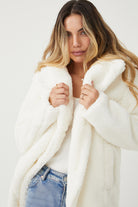Front view of the Bernie Ivory Jacket showing the collar neckline and longline button-up silhouette