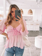 Women's pink sweetheart blouse with cutout tie detail and bubble sleeves, the Caroll Top in Pink by Esther & Co