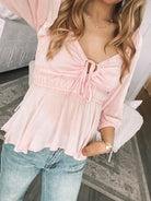 Women's pink bump friendly peplum blouse styled for spring by Esther & Co