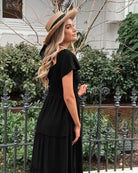 Side view of the Celie Dress in Black showing the midi length and relaxed A-line fit