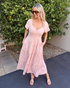 Side view of the Celie Dress in Pink showing the tiered detail and relaxed midi length