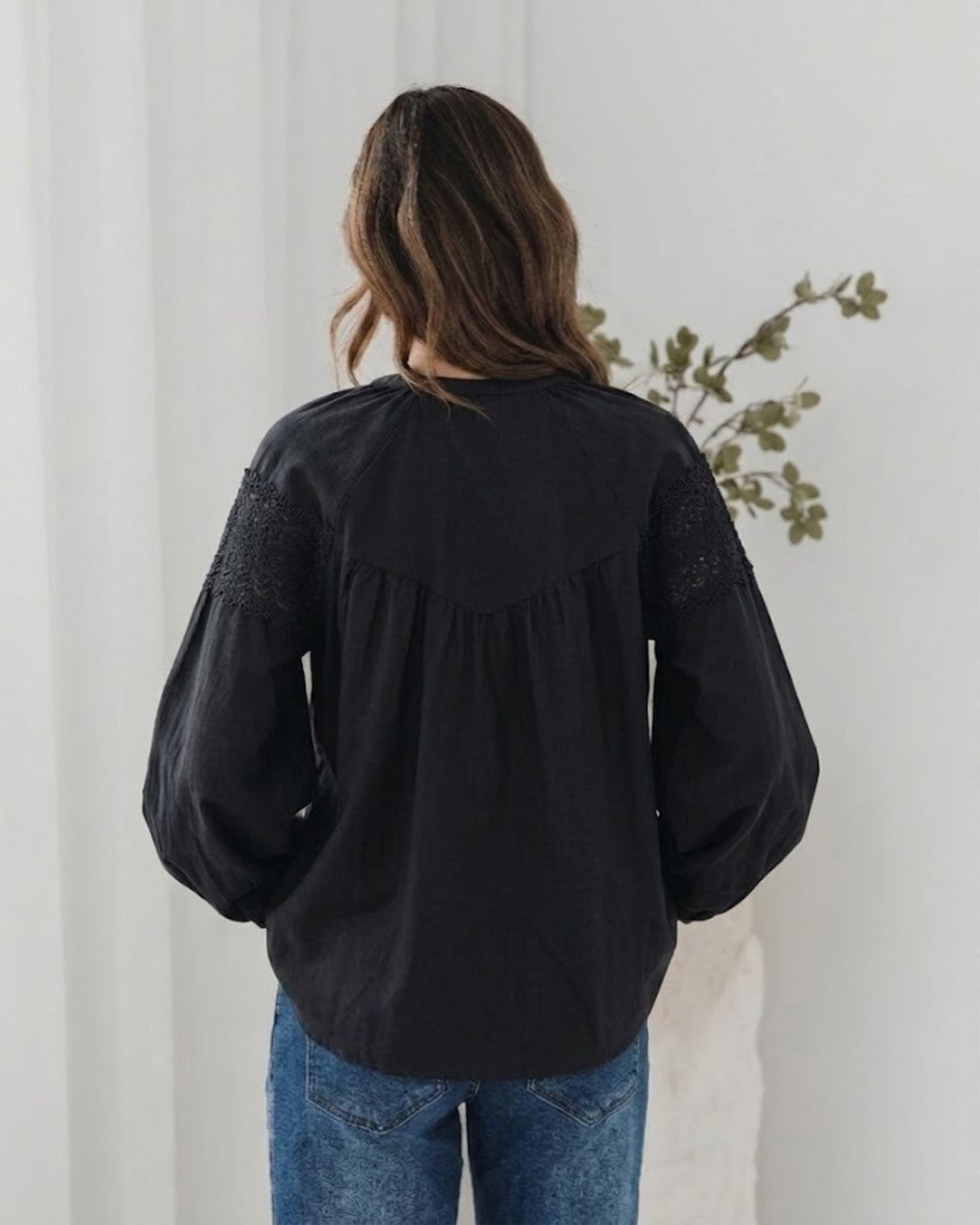 Women's black lace blouse with fabric tie detail styled with denim by Esther & Co