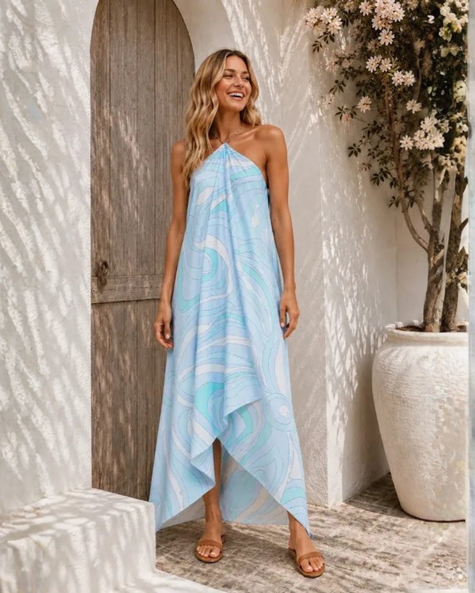 Women's blue halter neck maxi dress with asymmetrical hem, the Clairol Dress in Coastal Swirl by Esther & Co