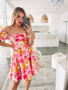 Women's flowy pink floral A-line mini dress styled for a garden party by Esther & Co