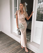 Model wearing the Doren Champagne Formal Dress styled with strappy gold heels for a wedding look