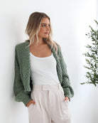 Model wearing the Dorine Forest Green Cardigan over a slip dress for an elevated brunch look
