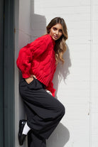 Model wearing the Hadi Red Knit Jumper styled with straight-leg jeans for a casual winter look