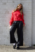 Side view of the Hadi Knit in Red showing the long sleeves and relaxed fit
