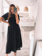 Model wearing the Iolana Dress in Black styled with heeled mules and gold jewellery