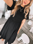 Full length view of the Iolana Dress in Black showing the flattering midi length and relaxed fit