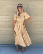 Side view of the Iolana Dress in Beige showing the flowing midi length and relaxed A-line fit