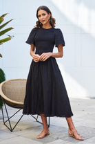 Flat lay of the Iolana Black Smock Midi Dress showing the round neckline and cotton fabric detail
