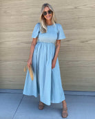 Women wearing the Iolana Dress in Sage, a cotton smock midi dress in soft blue-green sage with round neckline