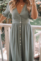 Side view of the Korbela Dress in Sage showing the flowing linen fabric and button-up front detail