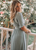 Front view of the Korbela Sage Linen Midi Dress showing the plunge neckline and A-line silhouette