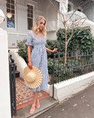 Women wearing the Korbel Dress in Blue Stripe, a relaxed linen midi dress with blue and white stripe print and V-neckline