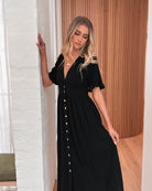 Model wearing the Korbela Dress in Black styled with heeled sandals for a dinner outfit