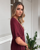 Korbela Dress in Bordeaux womens bordeaux linen midi dress close up frill detail