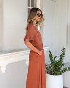 Korbela Dress in Rust rust linen midi dress with V-neckline and frill sleeves side view