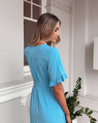 Side view of the Korbela Dress in Sky Blue showing the midi length and relaxed linen fit