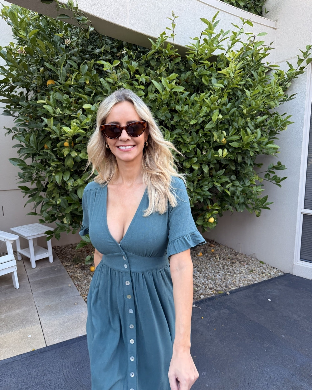 Front view of the Korbela Deep Green Linen Midi Dress showing the V-neckline and button-up detail