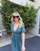 Front view of the Korbela Deep Green Linen Midi Dress showing the V-neckline and button-up detail