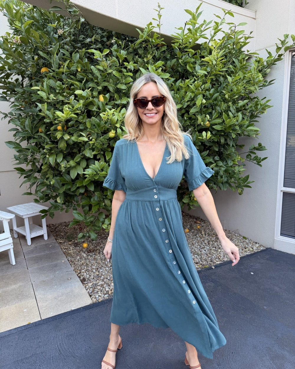 Side view of the Korbela Dress in Deep Green showing the relaxed A-line silhouette and midi length