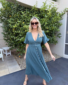 Side view of the Korbela Dress in Deep Green showing the relaxed A-line silhouette and midi length