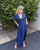 Women wearing the Korbela Dress in Navy, a relaxed linen blend midi dress with V-neckline and navy spot print