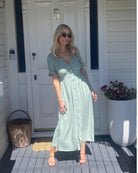 Full length view of the Korbela Dress in Sage showing the relaxed midi length and breathable linen fabric