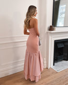 Elegant woman in a pink strapless dress with a ruffled hem, perfect for weddings, formal events, evening balls, and special occasions, standing gracefully.