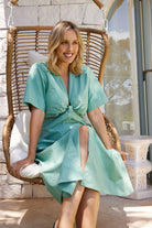 Women's sage midi dress styled with sandals by Esther & Co