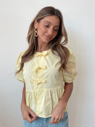 Women's yellow cotton peplum top with bow ties and puff sleeves, the Rayanna Top in Yellow by Esther & Co