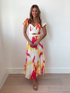 Women's white yellow pink maxi dress styled for an event by Esther & Co