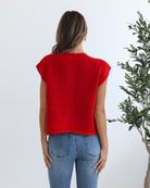 Women's red knit top styled with blue jeans by Esther & Co