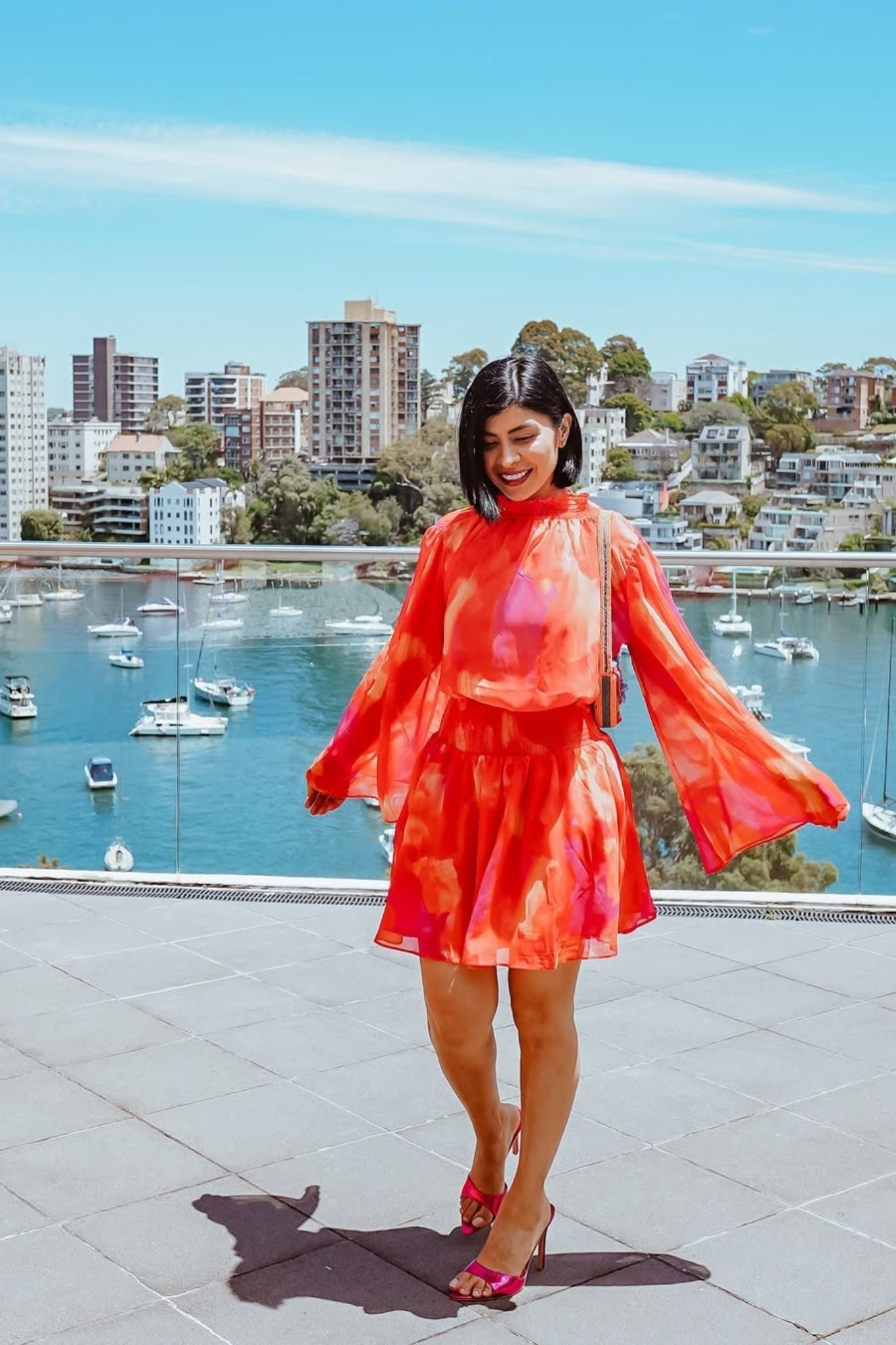 Influencer wearing the Daenerys Orange Print Mini Dress from Esther and Co