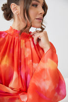Close-up detail of the Daenerys Mini Dress in Orange Print showing the vibrant floral print