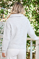 Side view of the Merete Knit in Grey showing the relaxed fit and long sleeves