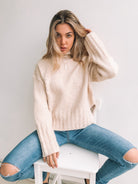 Women wearing the Chesterfield Jumper in Beige, a cosy heavyweight knit in neutral beige with mocha speckle detail